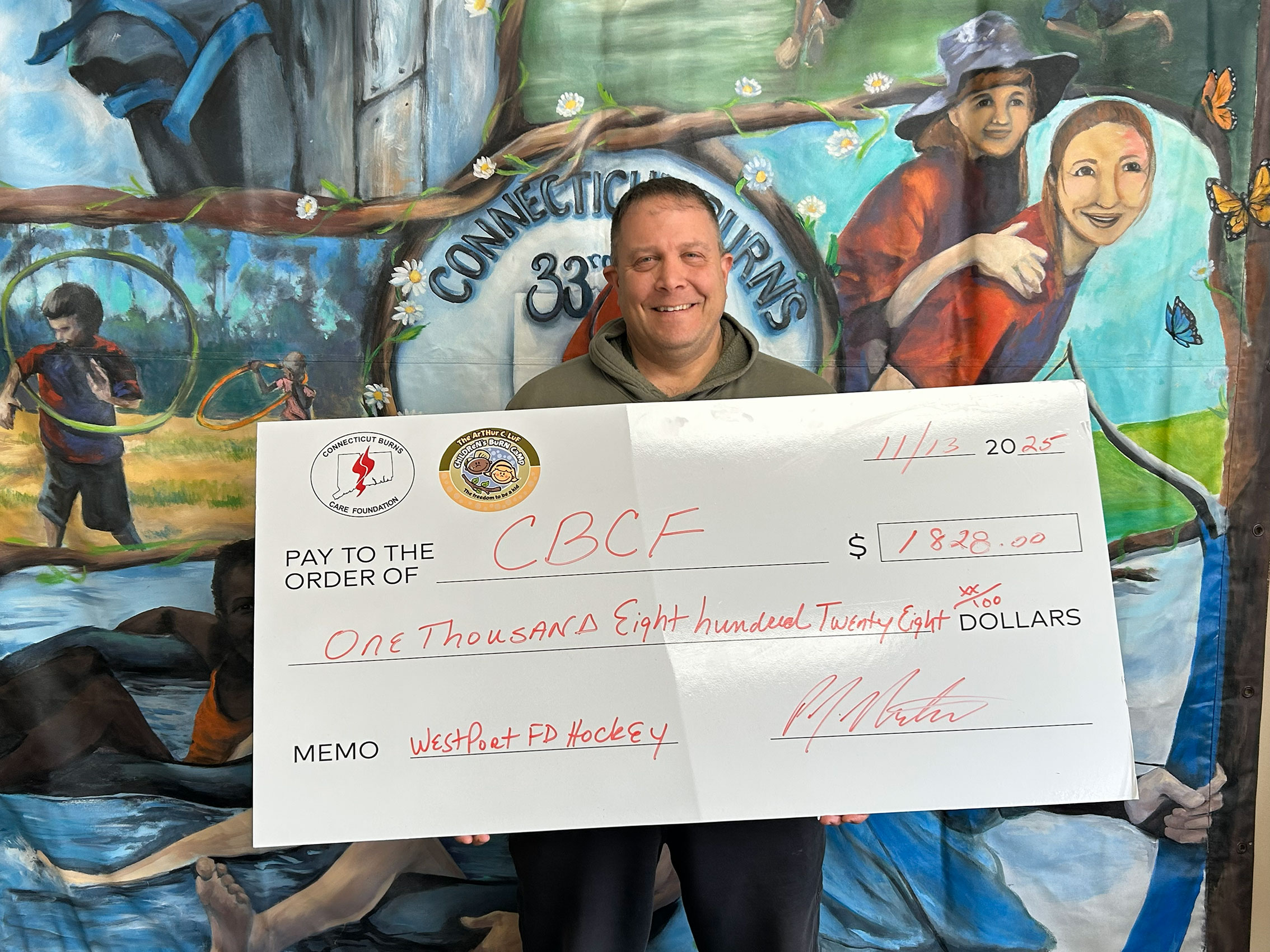 Phil Nichio, on behalf of the Westport FD presents the CBCF with a check of funds raised through their hockey tournament